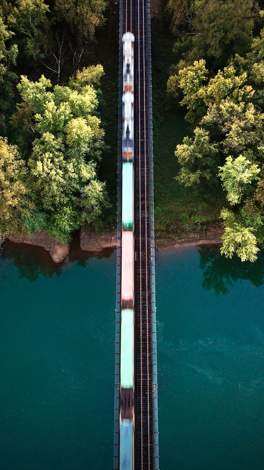 Aerial view of a freight train crossing a bridge over water